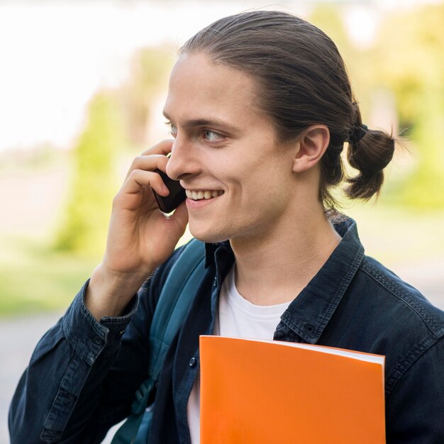 Handsome male student talking on the phone