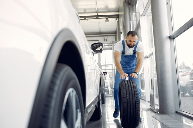 Handsome man in a blue uniform checks the car