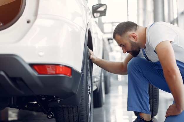 Handsome man in a blue uniform checks the car