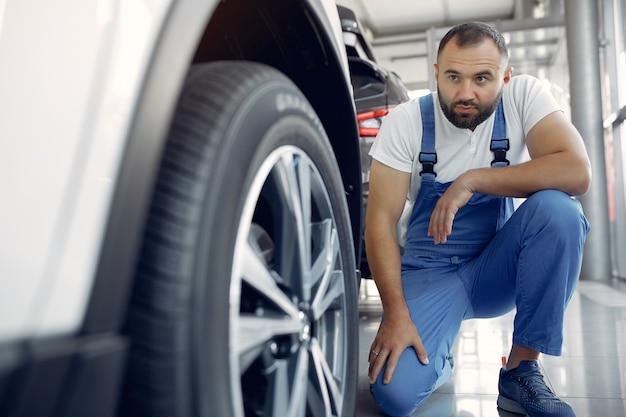 Free Photo handsome man in a blue uniform checks the car