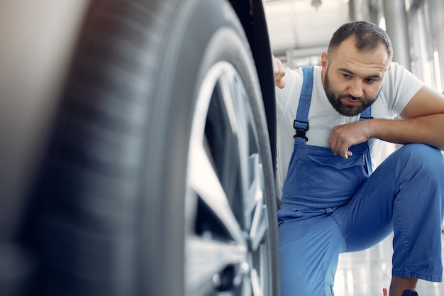 Free photo handsome man in a blue uniform checks the car