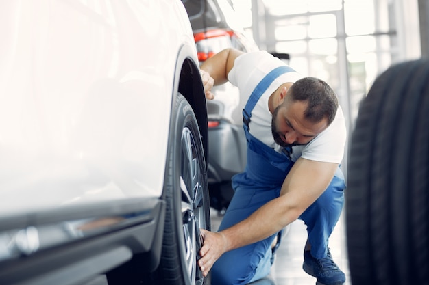 Free photo handsome man in a blue uniform checks the car