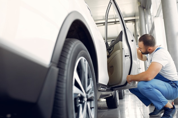 Free Photo handsome man in a blue uniform checks the car