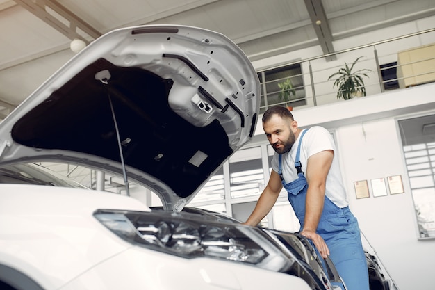 Free Photo handsome man in a blue uniform checks the car