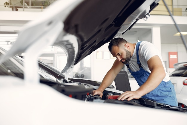 Free Photo handsome man in a blue uniform checks the car