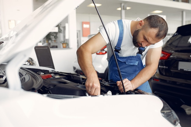 Handsome man in a blue uniform checks the car