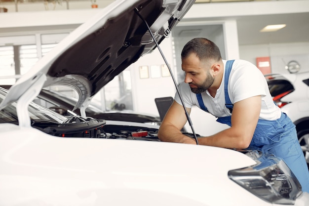 Handsome man in a blue uniform checks the car