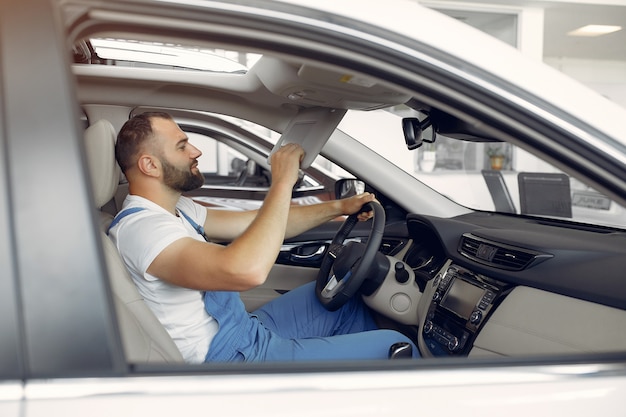 Handsome man in a blue uniform checks the car