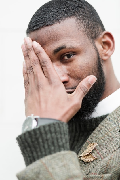 Handsome man covering his face with his hand