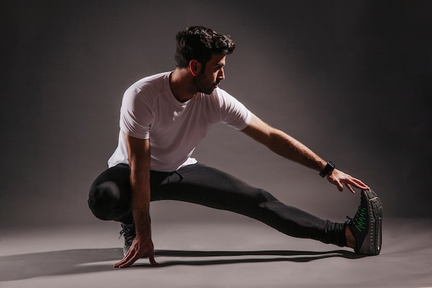 Handsome man exercising in dark studio