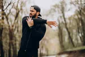 Free photo handsome man exercising in park in sports wear