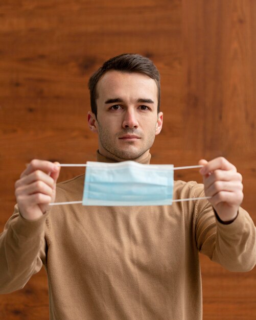 Handsome man holding a medical mask