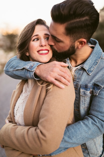 Handsome man kissing smiling woman