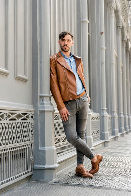 Handsome man leaning on metal pole