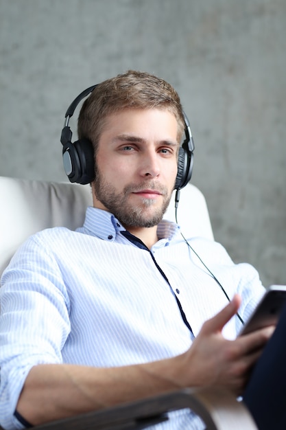 Handsome man listening podcast on headphones