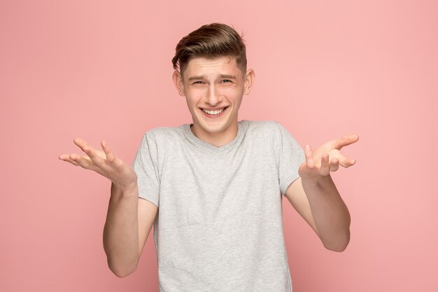 Handsome man looking suprised isolated on pink