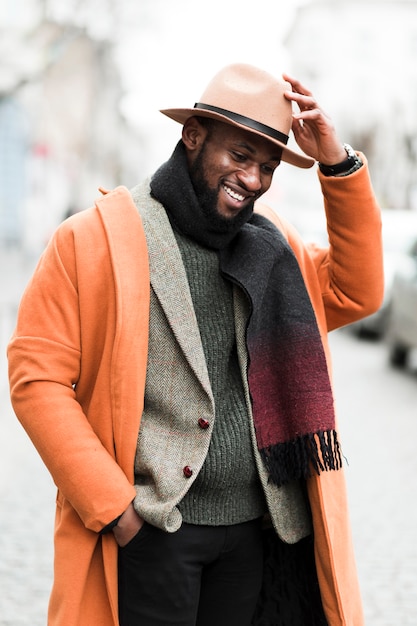 Handsome man in orange jacket posing outdoors