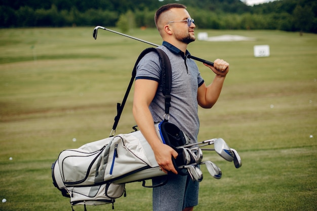 Free photo handsome man playing golf on a golf course