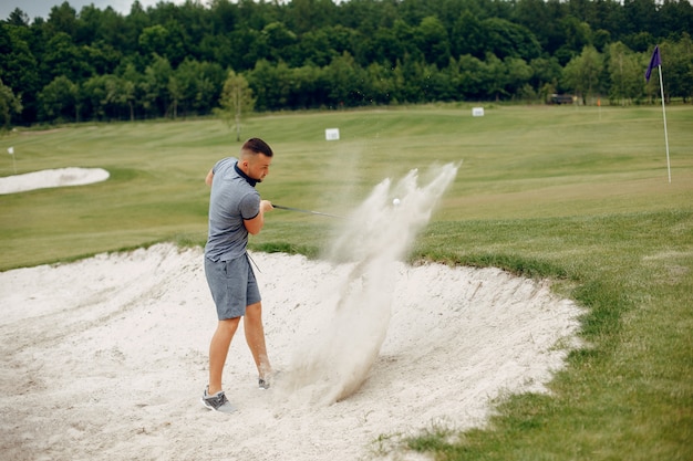 Free photo handsome man playing golf on a golf course