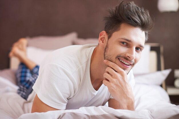 Handsome man resting in the morning on the bed