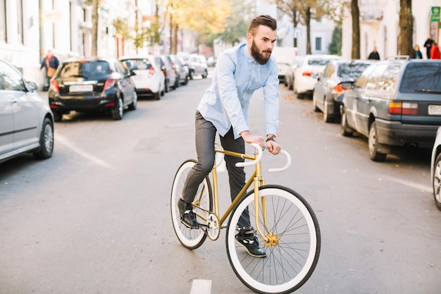 Free photo handsome man riding bicycle along road