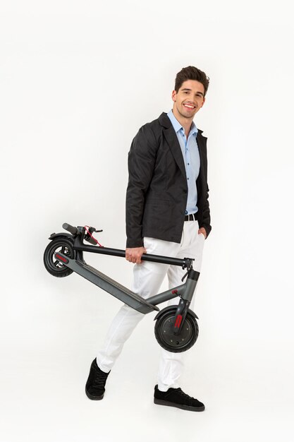 Handsome man riding on electic kick scooter isolated on white studio background