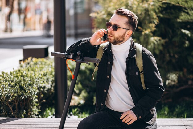 Free Photo handsome man on scooter shopping online on the phone