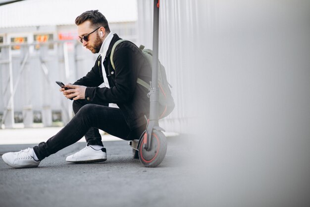 Handsome man on scooter shopping online on the phone