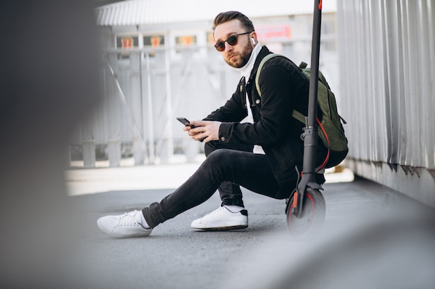 Handsome man on scooter shopping online on the phone