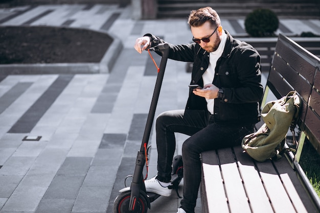 Handsome man on scooter shopping online on the phone