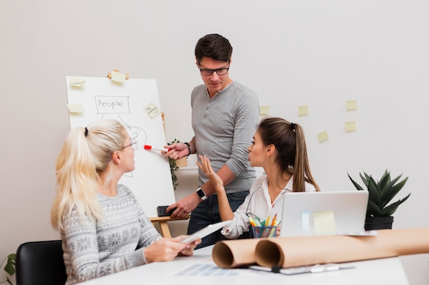 Free Photo handsome man showing a diagram to his partners