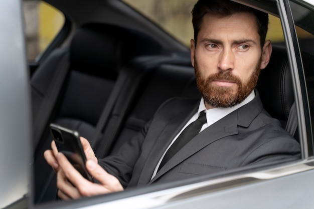 Free photo handsome man sitting in the back of a cab