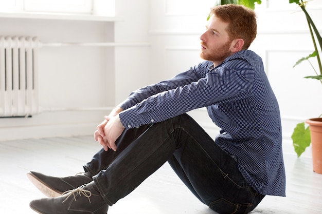 Handsome man sitting on the floor