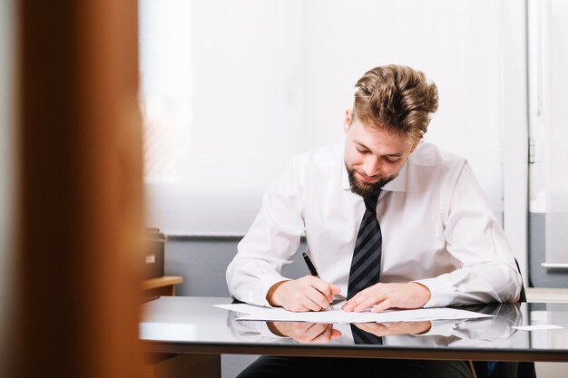 Handsome man sitting and writing