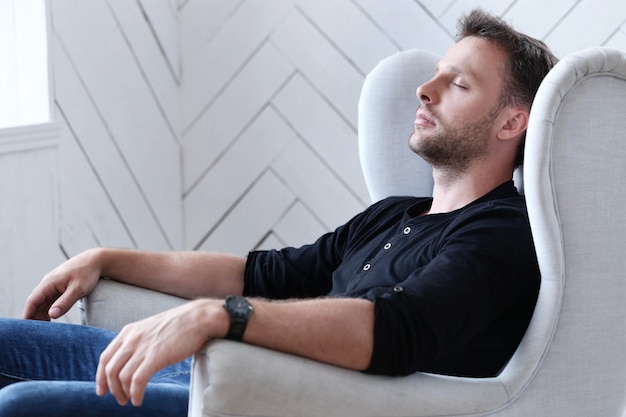 Free photo handsome man sleeping on the armchair