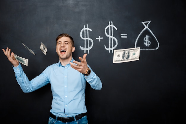 Free photo handsome man standing over blackboard  with drawn dollar concept