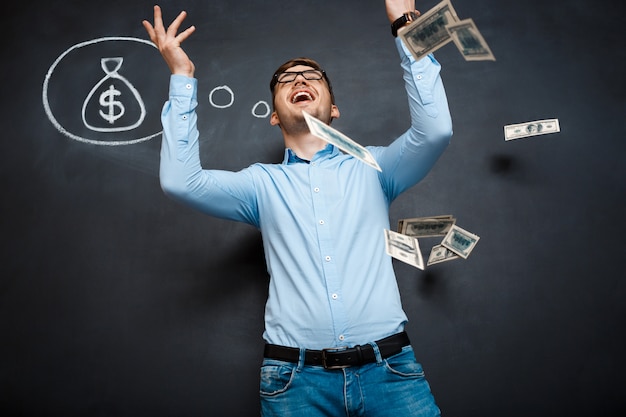 Free photo handsome man standing over blackboard  with drawn dollar concept