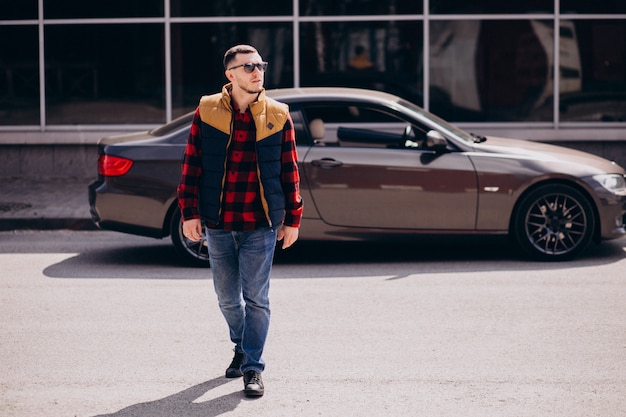 Handsome man standing by the car