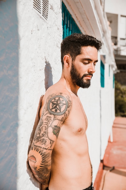 Free photo handsome man standing near building on resort