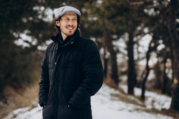 Handsome man standing in a winter park