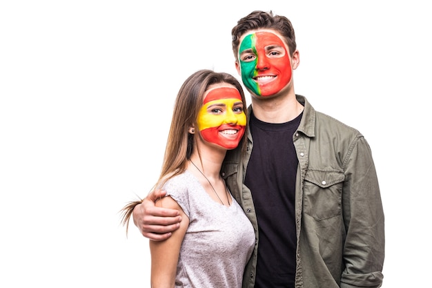 Free Photo handsome man supporter fan of portugal national team painted flag face hug woman supporter fan of spain national team. fans emotions.