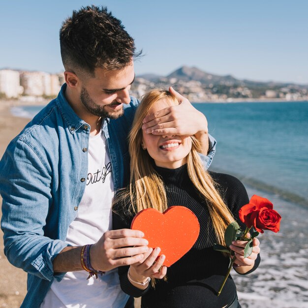 Handsome man surprising girl with present