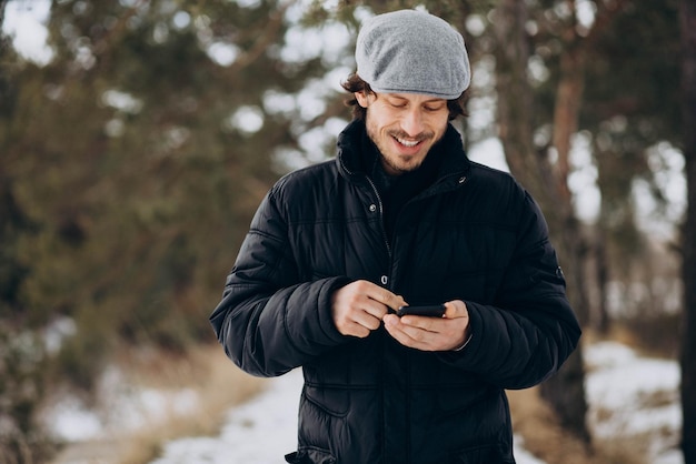 Handsome man talking on the phone in a winter park