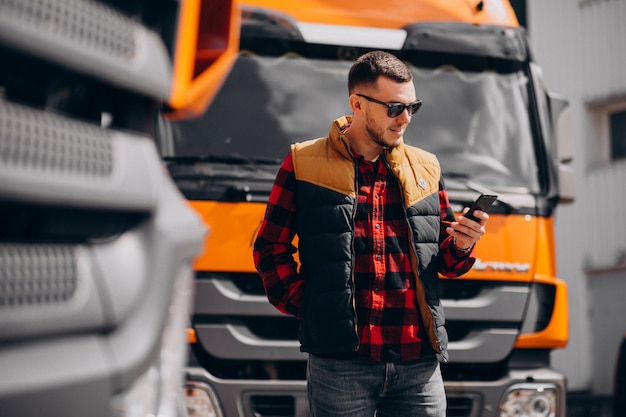 Free photo handsome man truck driver standing by the truck