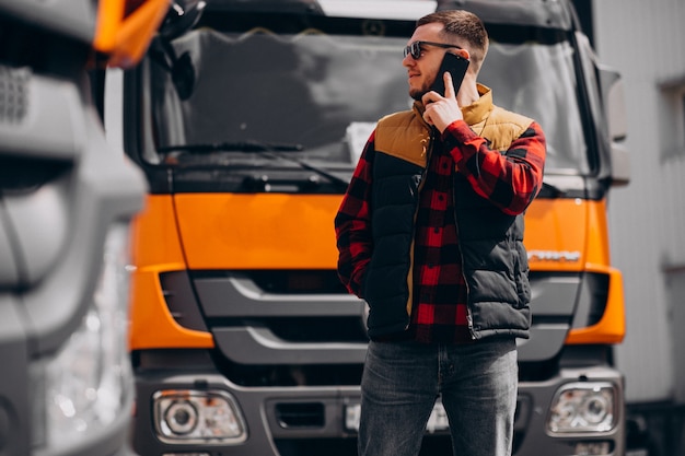 Free Photo handsome man truck driver standing by the truck