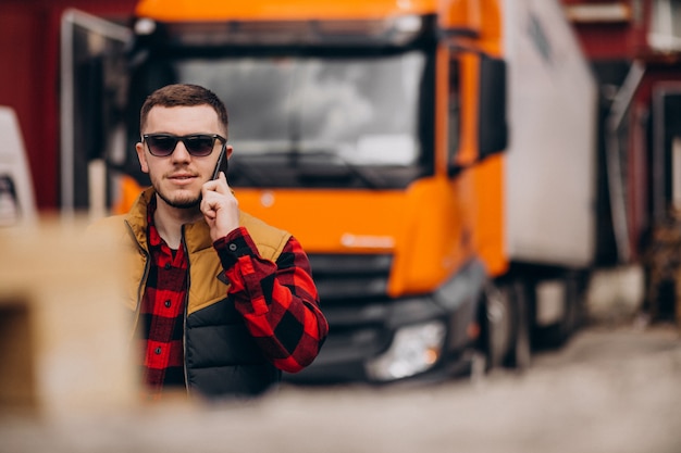 Free photo handsome man truck driver standing by the truck