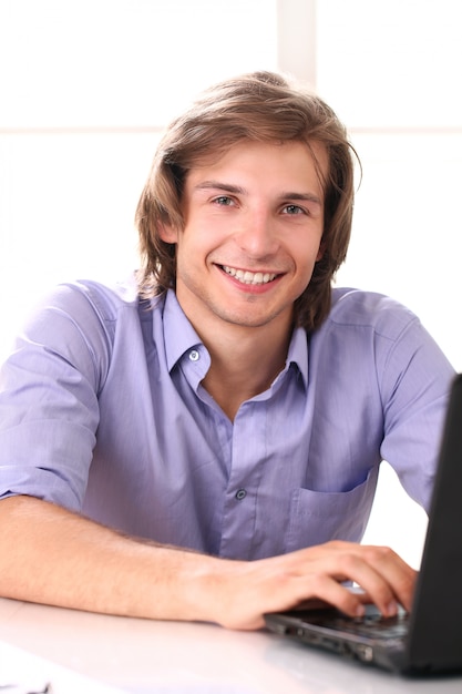 Handsome man using laptop in his office