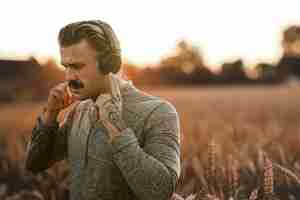 Free photo handsome man wearing wireless headphones with nature view remixed media