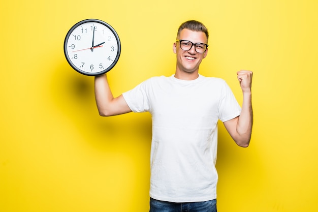 Handsome man in white t-shirt and transperent glasses hold big clock in one hand