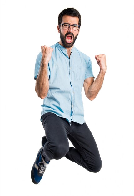 Handsome man with blue glasses jumping